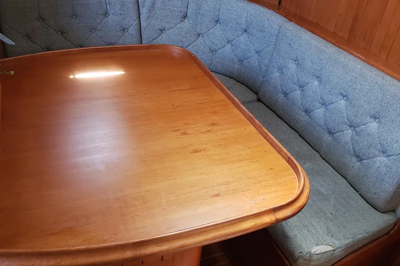 Slide: The Image of Cozy dining area with wooden table and cushioned seating in 1987 Hans Christian 33 yacht. - 33
