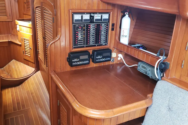 Slide: The Image of 1987 Hans Christian 33 yacht interior with wooden paneling and navigation equipment. - 34