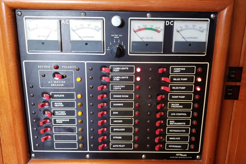 Slide: The Image of Electrical control panel on a 1987 Hans Christian 33 sailboat, featuring AC/DC meters and switches. - 35