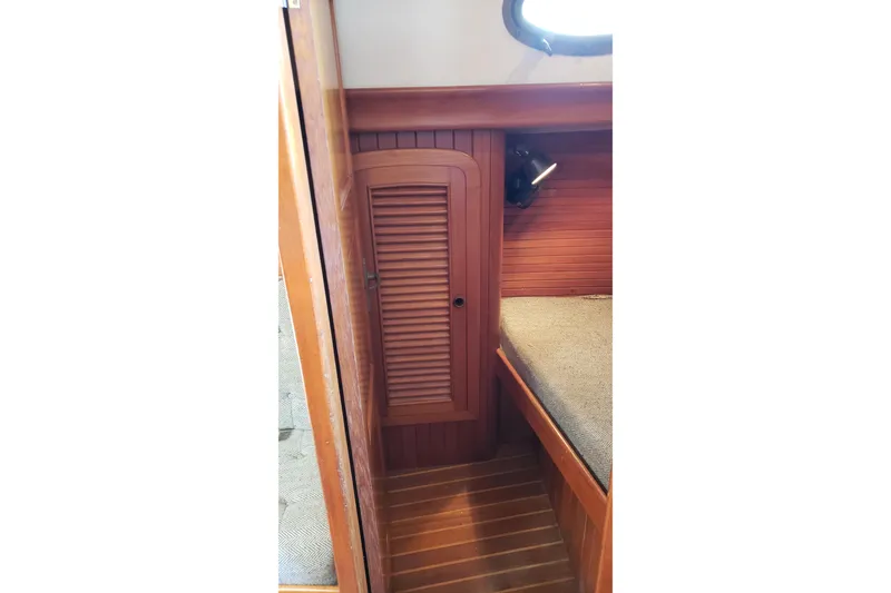 Slide: The Image of Interior of 1987 Hans Christian 33 sailboat with wooden cabinetry and cozy berth. - 39