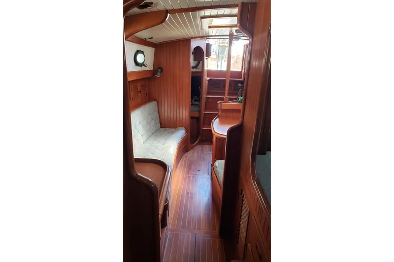 Slide: The Image of Interior of 1987 Hans Christian 33 sailboat, featuring wooden paneling and cozy seating. - 43
