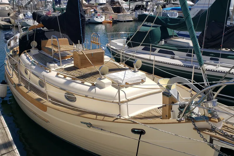 Slide: The Image of 1987 Hans Christian 33 sailboat docked in a marina, showcasing classic design and wooden deck. - 5