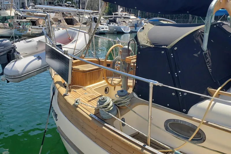 Slide: The Image of 1987 Hans Christian 33 sailboat docked, featuring wooden deck and solar panel. - 6