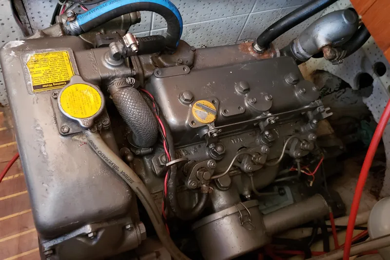 Slide: The Image of Engine of a 1987 Hans Christian 33 sailboat, showcasing mechanical components and hoses. - 60