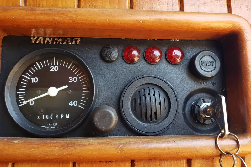 Slide: The Image of Yanmar engine control panel on a 1987 Hans Christian 33 sailboat, featuring RPM gauge and start button. - 62