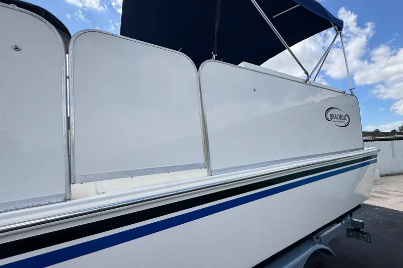 Slide: The Image of 2018 Beachcat 20 boat with blue canopy, side view under clear sky. - 10