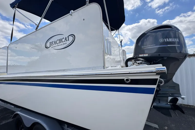 Slide: The Image of 2018 Beachcat 20 pontoon boat with Yamaha motor, under a blue sky. - 13