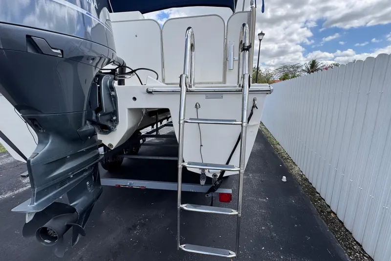 Slide: The Image of Rear view of a 2018 Beachcat 20 boat with ladder and outboard motor. - 18