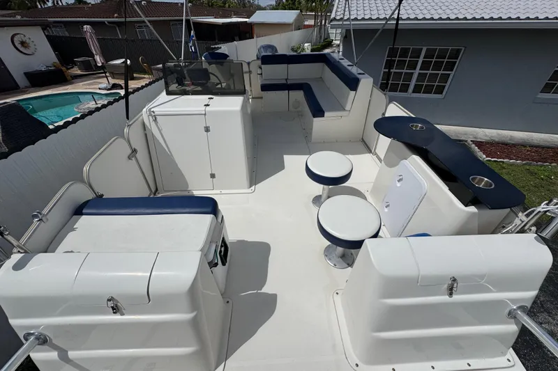 Slide: The Image of 2018 Beachcat 20 boat interior with seating, stools, and a small bar area. - 20