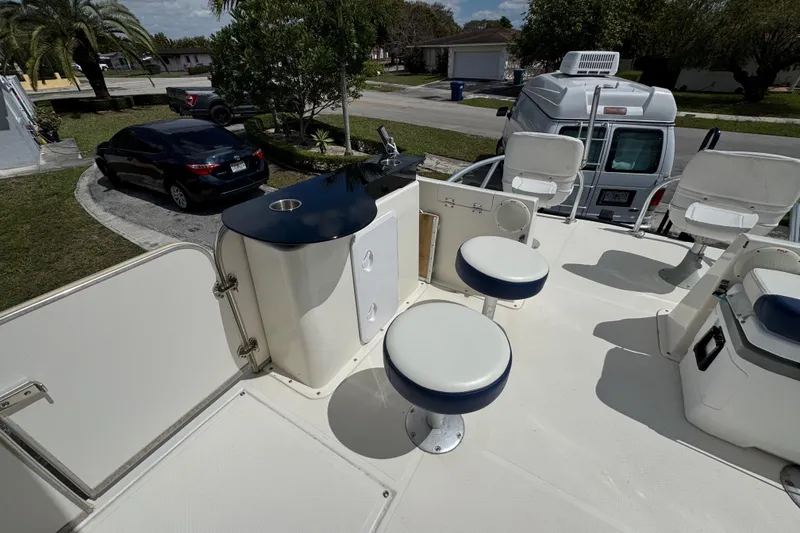 Slide: The Image of 2018 Beachcat 20 boat deck with seating and storage, parked in a residential area. - 27