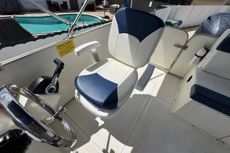 Slide: The Image of Captain's seat on a 2018 Beachcat 20 boat, near a swimming pool. - 32
