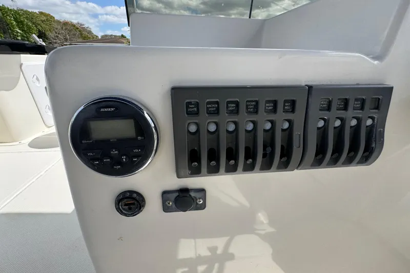 Slide: The Image of Control panel of a 2018 Beachcat 20 boat with switches and a Jensen stereo. - 38