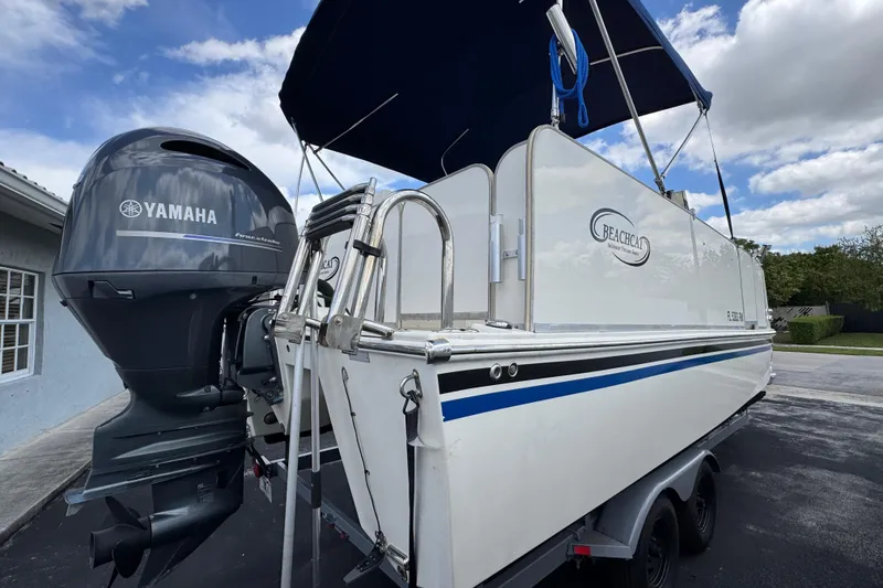 Slide: The Image of 2018 Beachcat 20 boat with Yamaha outboard motor, parked outdoors under a blue sky. - 4