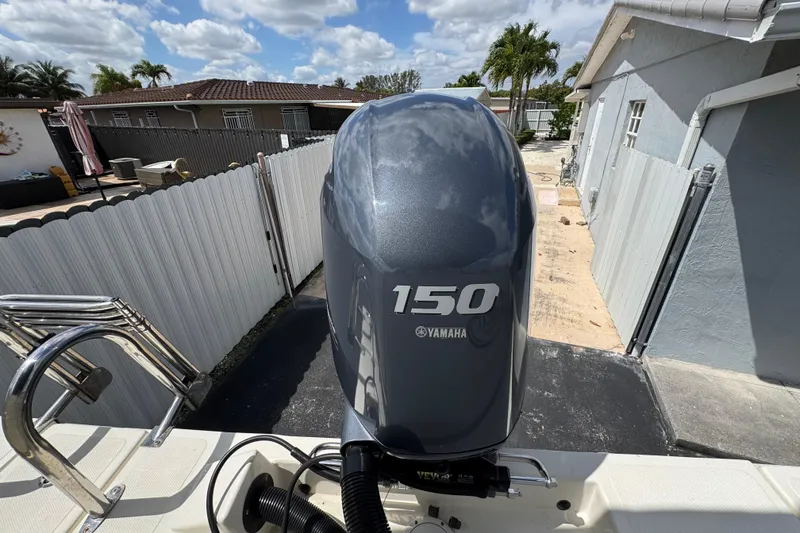 Slide: The Image of Yamaha 150 outboard motor on a 2018 Beachcat 20 boat, parked in a driveway. - 44