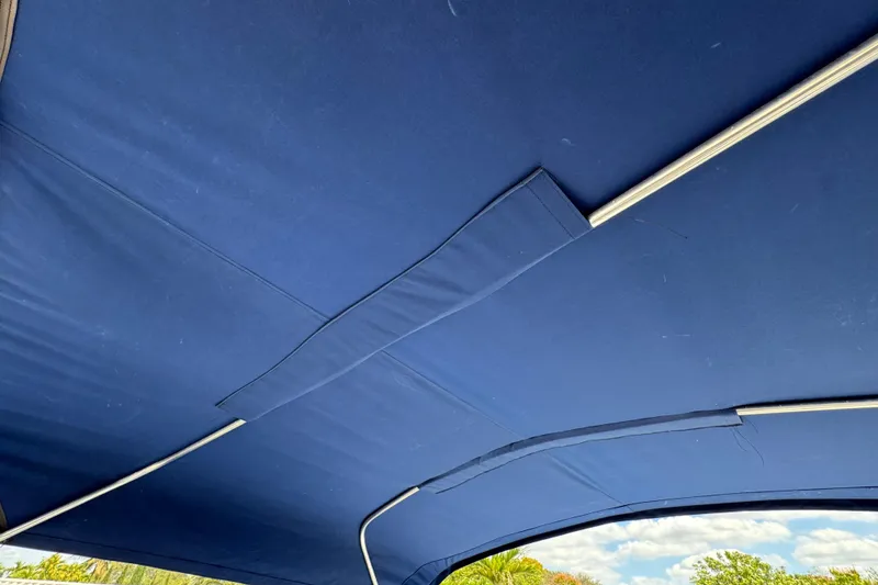 Slide: The Image of Blue canopy of a 2018 Beachcat 20 boat with metal support rods. - 45