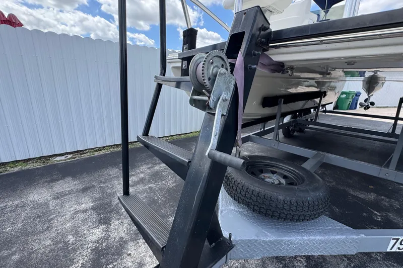 Slide: The Image of Trailer stairs and winch of a 2018 Beachcat 20 boat under a cloudy sky. - 51