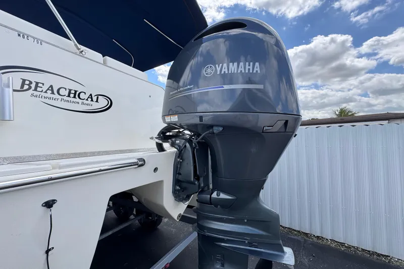 Slide: The Image of 2018 Beachcat 20 pontoon boat with Yamaha outboard motor, under a partly cloudy sky. - 7
