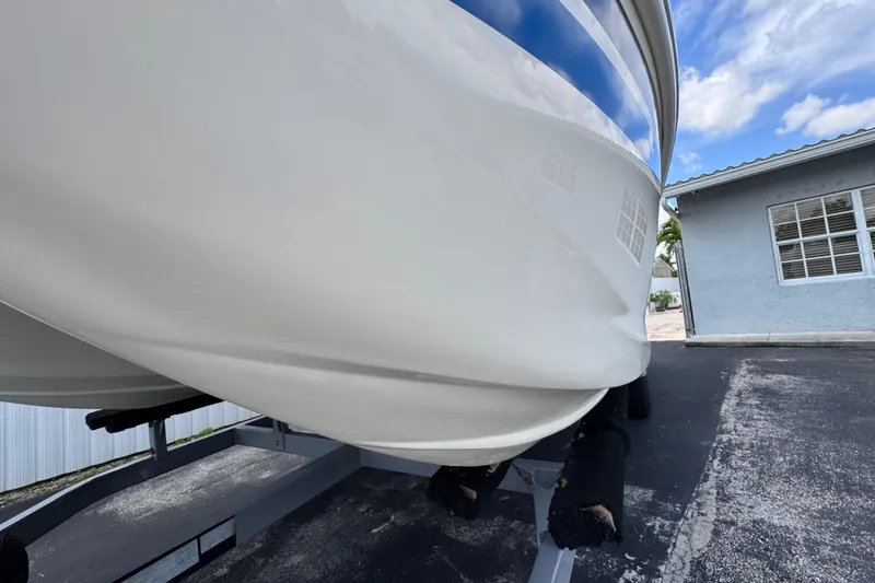 Slide: The Image of 2018 Beachcat 20 boat on trailer, parked near a blue building under a cloudy sky. - 8