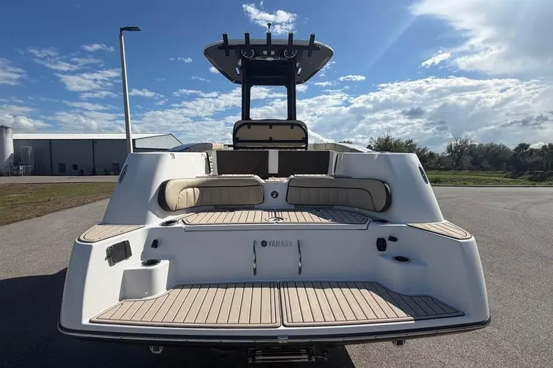 Slide: The Image of 2023 Yamaha Boats 255 FSH Sport E, rear view, showcasing spacious deck and seating. - 10
