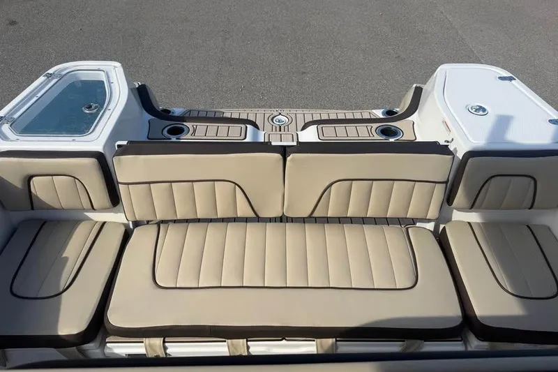 Slide: The Image of 2023 Yamaha Boats 255 FSH Sport E interior with beige seating and cup holders. - 11