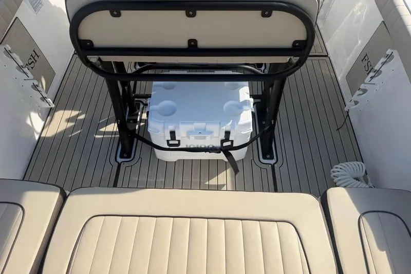 Slide: The Image of 2023 Yamaha Boats 255 FSH Sport E interior with cooler and seating. - 12