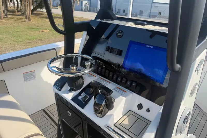 Slide: The Image of 2023 Yamaha Boats 255 FSH Sport E dashboard with steering wheel and navigation display. - 16