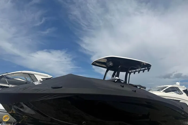 Slide: The Image of 2023 Yamaha Boats 255 FSH Sport E, covered, docked under a partly cloudy sky. - 19