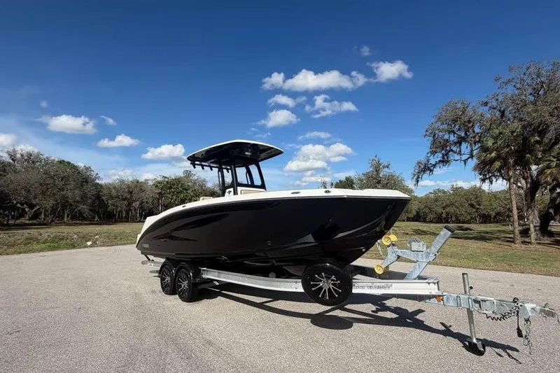 Slide: The Image of 2023 Yamaha Boats 255 FSH Sport E on trailer under clear blue sky. - 2