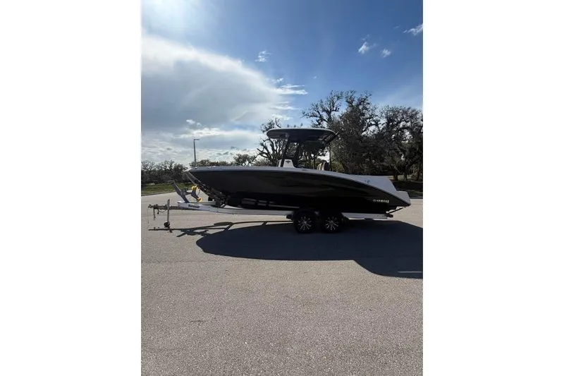 Slide: The Image of 2023 Yamaha Boats 255 FSH Sport E on trailer under a partly cloudy sky. - 3