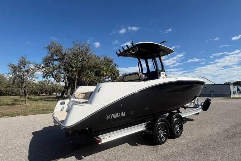 Slide: The Image of 2023 Yamaha Boats 255 FSH Sport E on trailer, parked outdoors under clear sky. - 4
