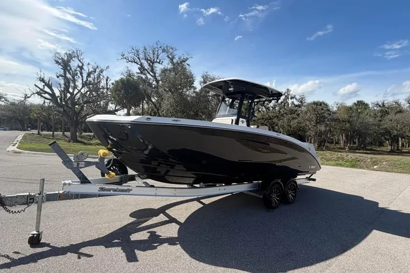 Slide: The Image of 2023 Yamaha Boats 255 FSH Sport E on trailer, parked outdoors under a clear blue sky. - 6