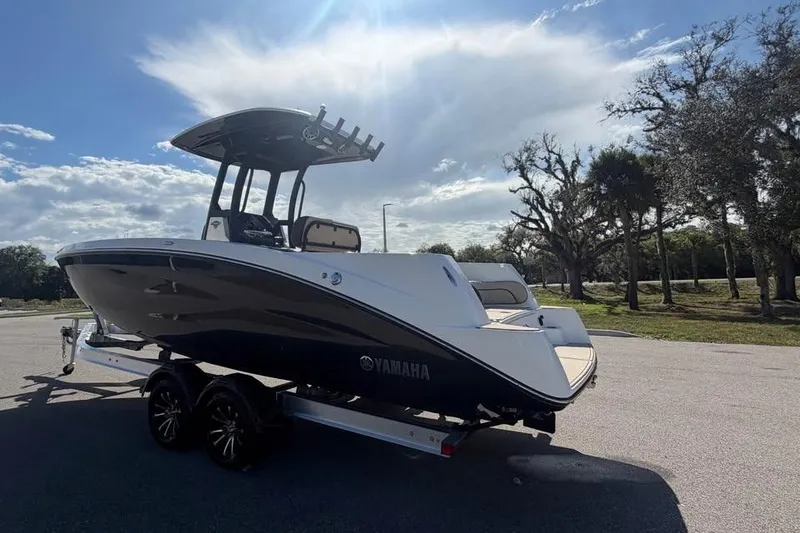 Slide: The Image of 2023 Yamaha Boats 255 FSH Sport E on trailer under sunny sky. - 7