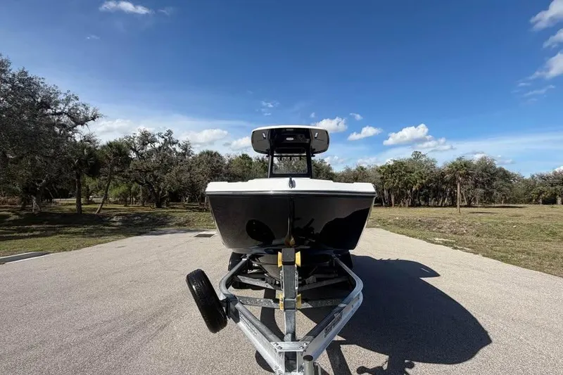 Slide: The Image of 2023 Yamaha Boats 255 FSH Sport E on trailer, parked outdoors under blue sky. - 8