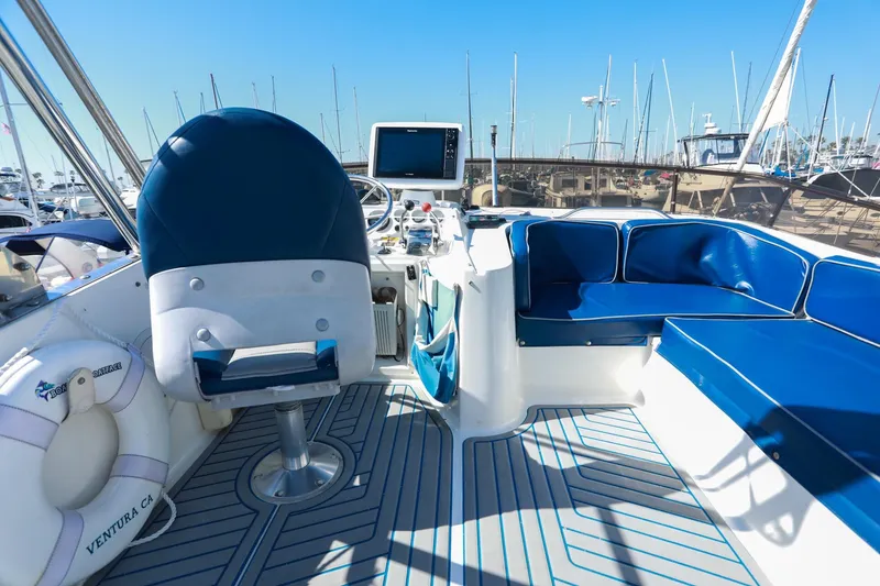 Slide: The Image of 1988 Mediterranean 38 Convertible boat interior with blue seating and steering area. - 14