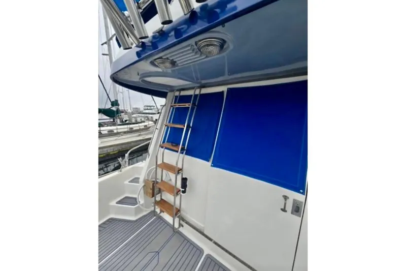 Slide: The Image of 1988 Mediterranean 38 Convertible yacht with blue accents and ladder on deck. - 20