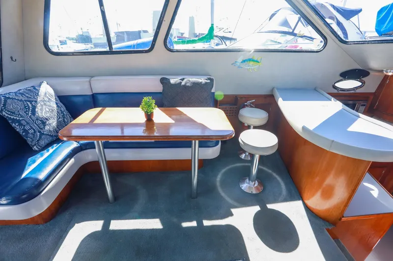 Slide: The Image of Interior of 1988 Mediterranean 38 Convertible yacht with cozy seating and wooden table. - 29