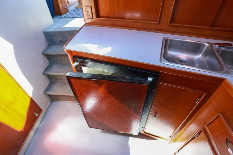 Slide: The Image of 1988 Mediterranean 38 Convertible yacht kitchen with wooden cabinets and stainless steel sink. - 38