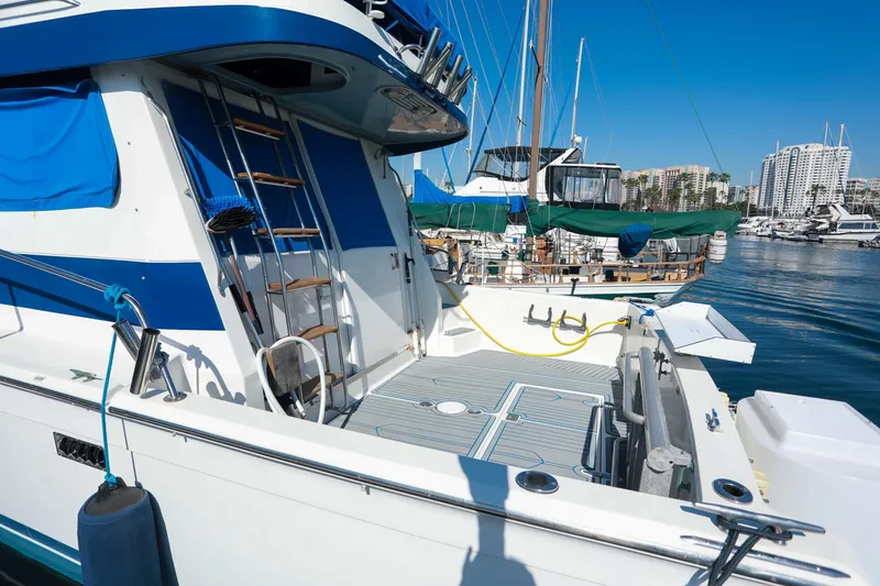 Slide: The Image of 1988 Mediterranean 38 Convertible yacht docked at marina, featuring blue accents and ladder. - 4