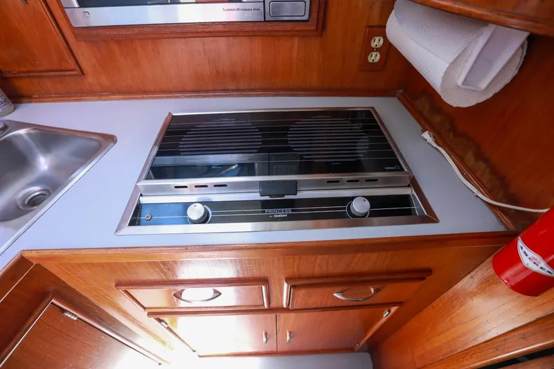 Slide: The Image of 1988 Mediterranean 38 Convertible yacht kitchen with stove, sink, and wooden cabinetry. - 41
