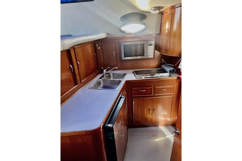 Slide: The Image of 1988 Mediterranean 38 Convertible yacht kitchen with wooden cabinets and modern appliances. - 42