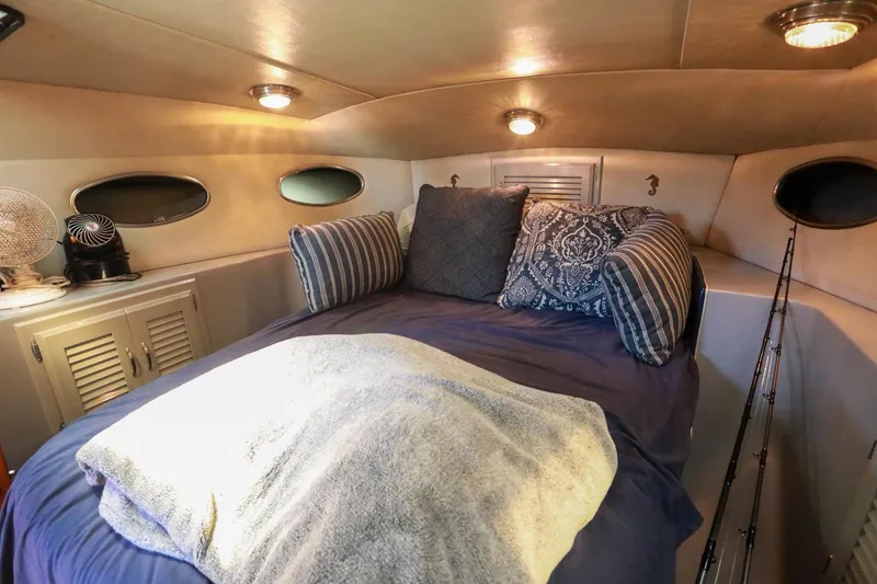 Slide: The Image of Cozy cabin interior of 1988 Mediterranean 38 Convertible yacht with plush bedding and ambient lighting. - 45