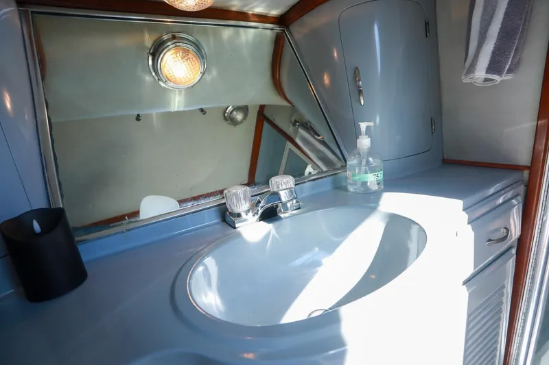 Slide: The Image of Bathroom sink area in a 1988 Mediterranean 38 Convertible yacht, featuring a mirror and faucet. - 46