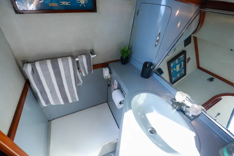 Slide: The Image of Bathroom interior of 1988 Mediterranean 38 Convertible yacht, featuring sink and striped towel. - 47