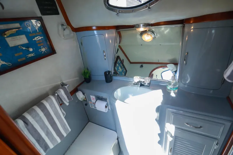 Slide: The Image of Bathroom interior of 1988 Mediterranean 38 Convertible yacht, featuring sink, mirror, and nautical decor. - 48
