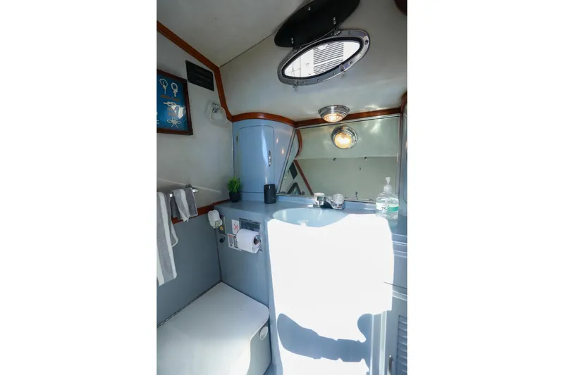 Slide: The Image of 1988 Mediterranean 38 Convertible yacht bathroom with sink, mirror, and nautical decor. - 49