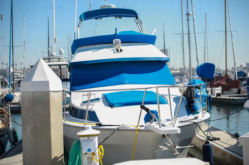 Slide: The Image of 1988 Mediterranean 38 Convertible yacht docked at marina, featuring blue and white design. - 6