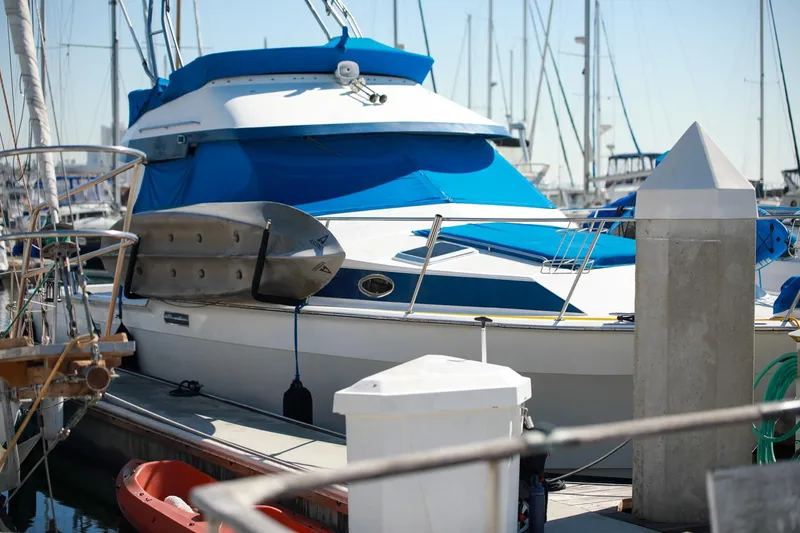 Slide: The Image of 1988 Mediterranean 38 Convertible yacht docked with blue covers and kayak. - 7