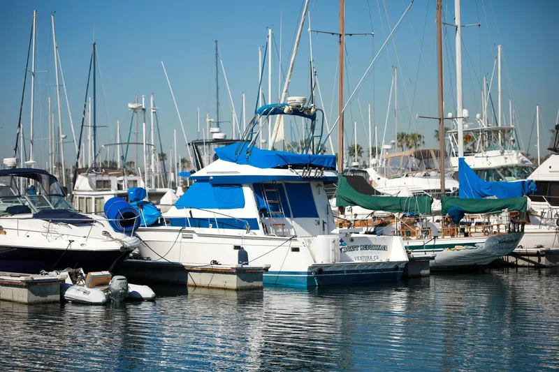 Slide: The Image of 1988 Mediterranean 38 Convertible yacht docked in a marina, surrounded by other boats. - 8