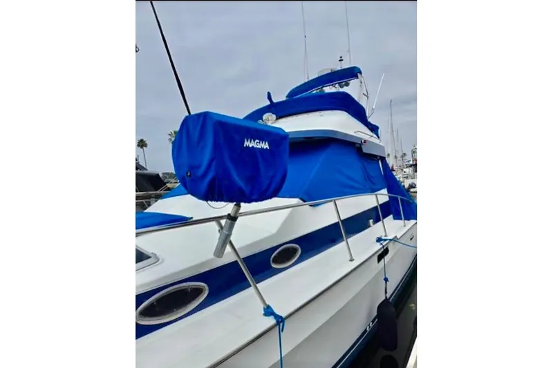 Slide: The Image of 1988 Mediterranean 38 Convertible yacht with blue covers docked at marina. - 9