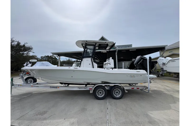 The Image of 2026 Caymas 26 HB boat on trailer, parked outdoors near a building. - 1